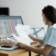 Woman sitting at desk looking at excel sheet whole reviewing documents